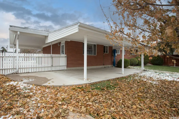Brick exterior with an expansive concrete patio and white picket fencing