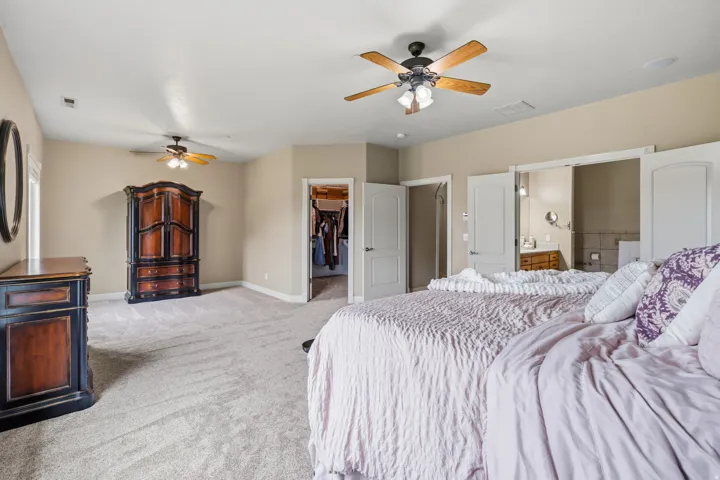 Spacious room featuring neutral carpeting, recessed lighting, and two ceiling fans