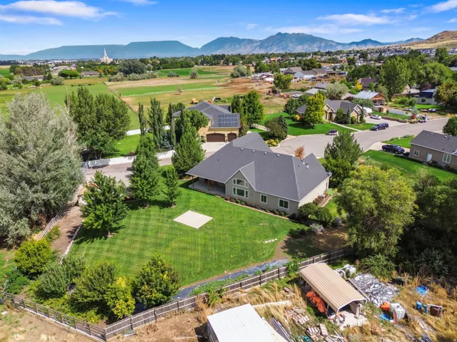 Expansive residential property with a vast lawn, mature trees, and mountainous terrain in the background