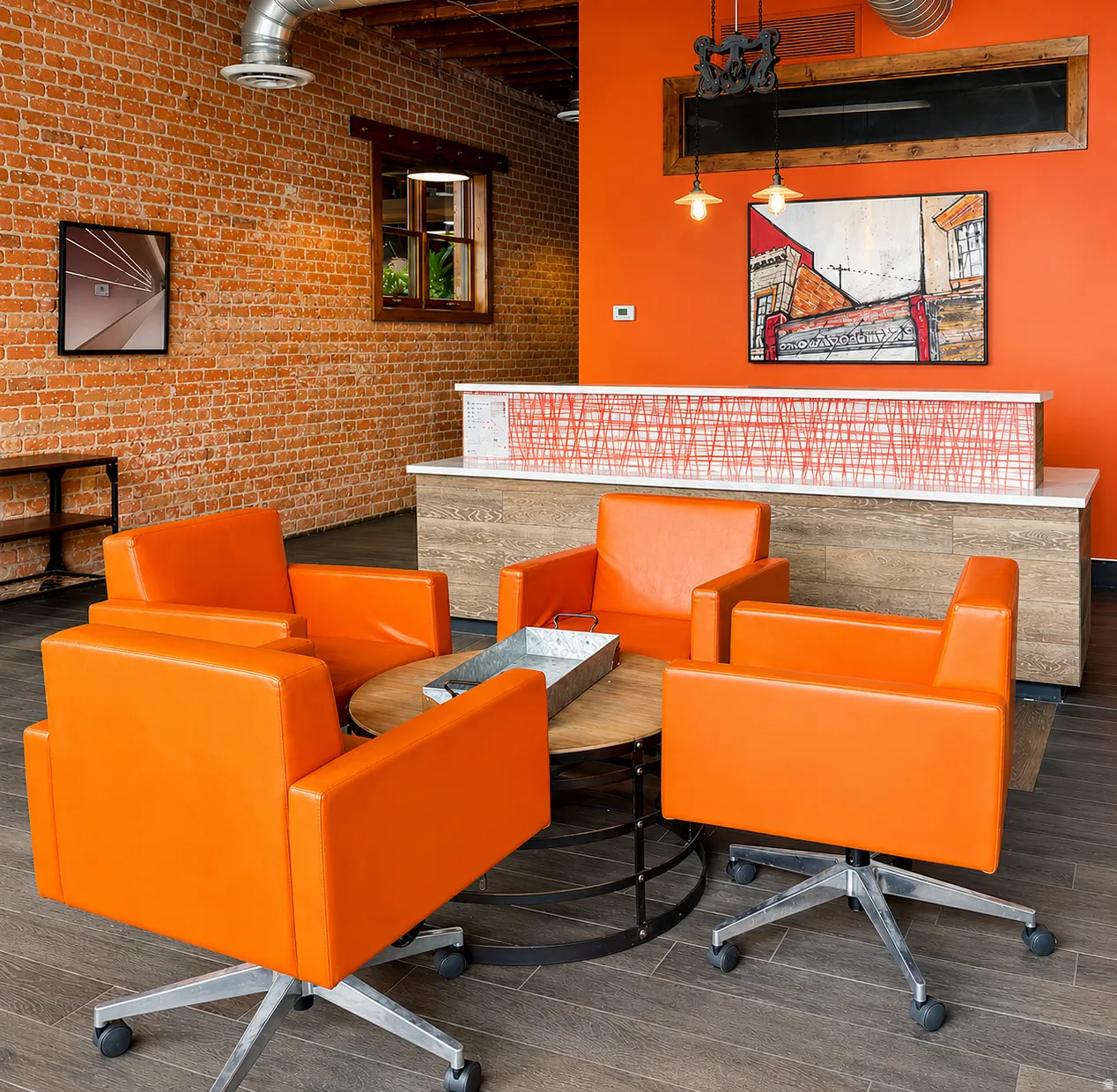 Exposed brick wall with ductwork, wood-finish flooring, and a built-in reception desk with a white countertop