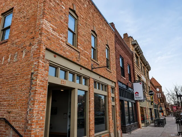 Brick exterior facade featuring multiple large windows and decorative architectural elements