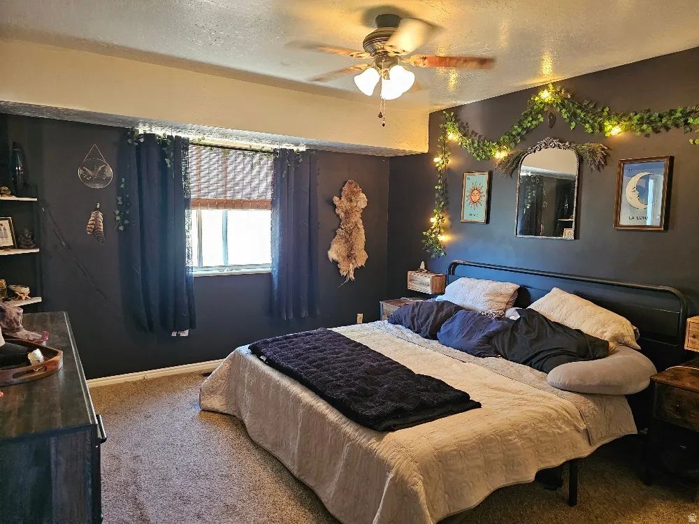 Carpeted flooring, window with blinds, ceiling fan with light fixture, built-in shelving