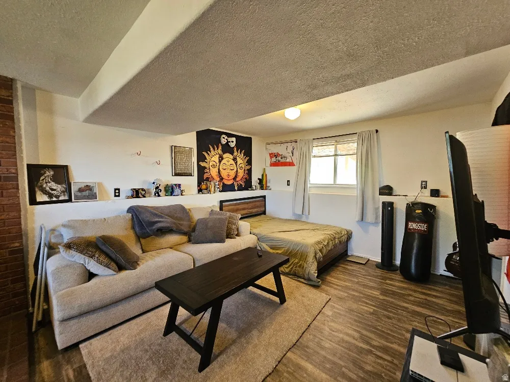 Wood-finish flooring, white painted walls, and a window with white trim