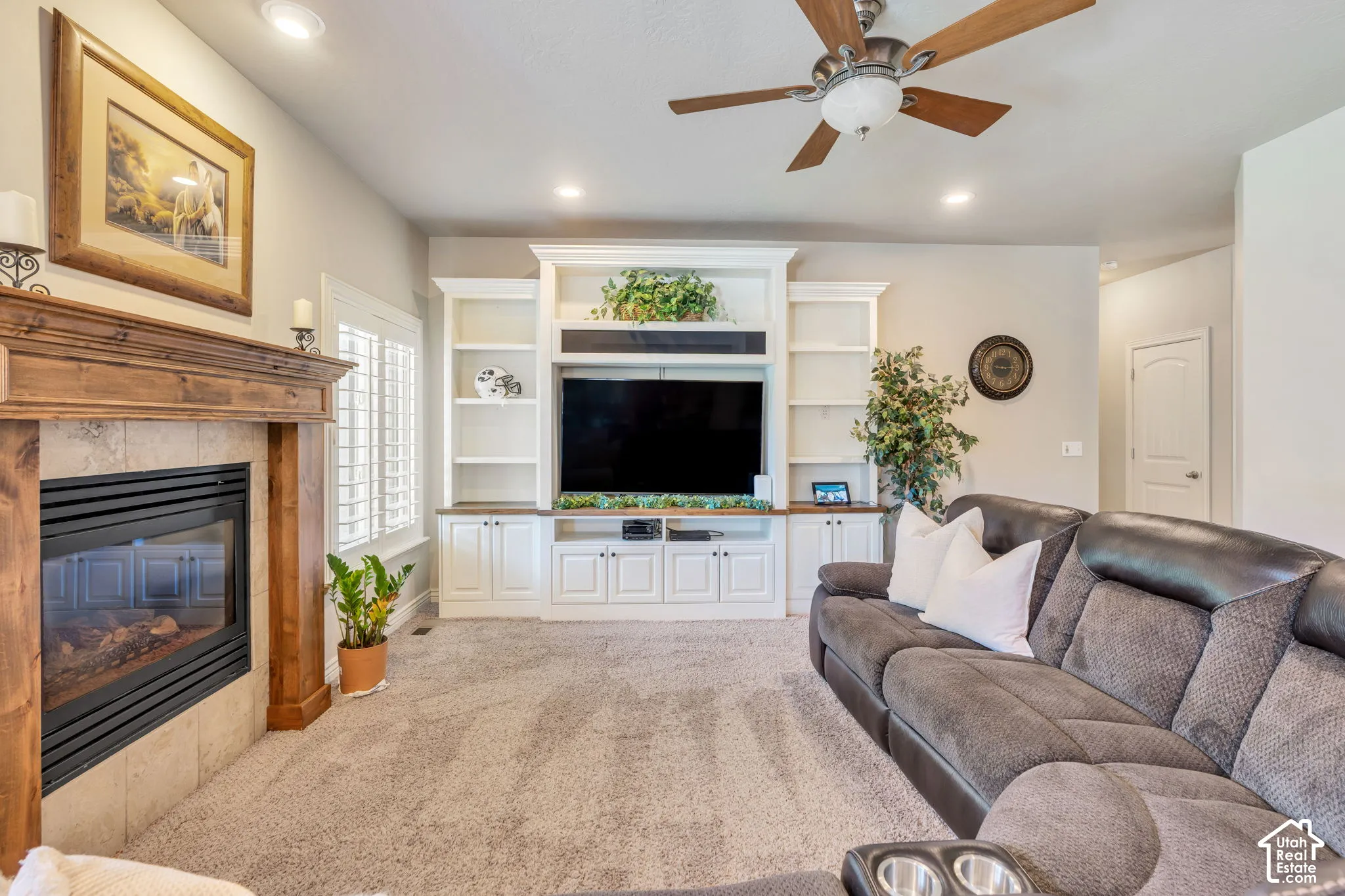 Built-in entertainment center, fireplace, recessed lighting, wood-finish ceiling fan, wood-mantle fireplace with tile surround, plantation shutters
