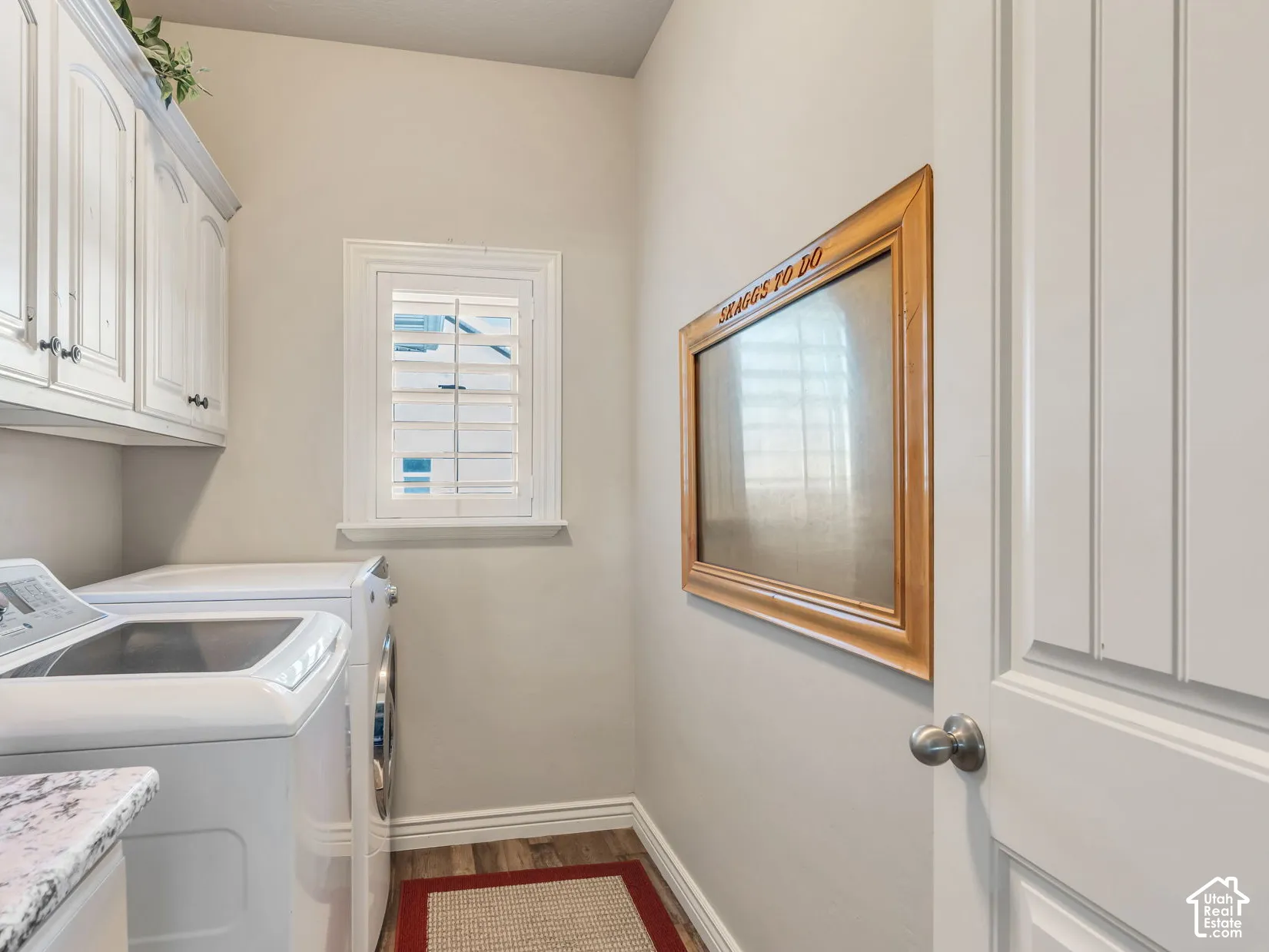 Laundry room with granite countertop and white cabinets