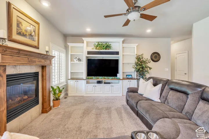 Built-in entertainment center, fireplace, recessed lighting, wood-finish ceiling fan, wood-mantle fireplace with tile surround, plantation shutters