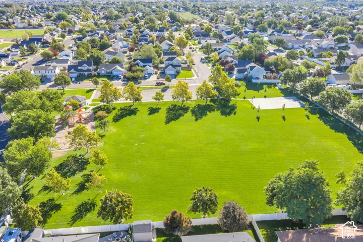 Beautiful neighborhood park with playground, mature trees, paved pathways, and a sports court