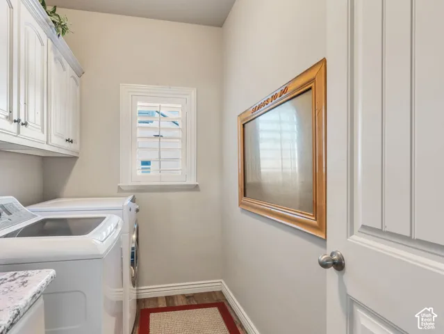 Laundry room with granite countertop and white cabinets