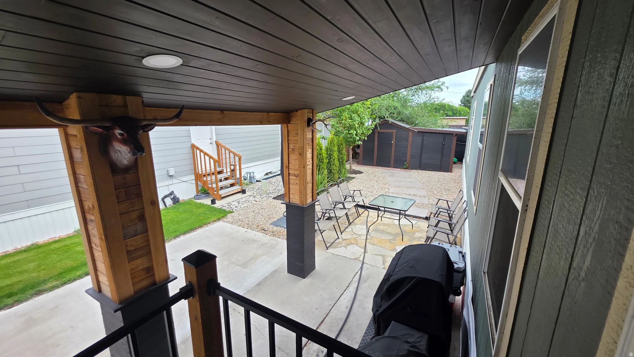 Covered outdoor patio with wood-clad pillars and recessed lighting
