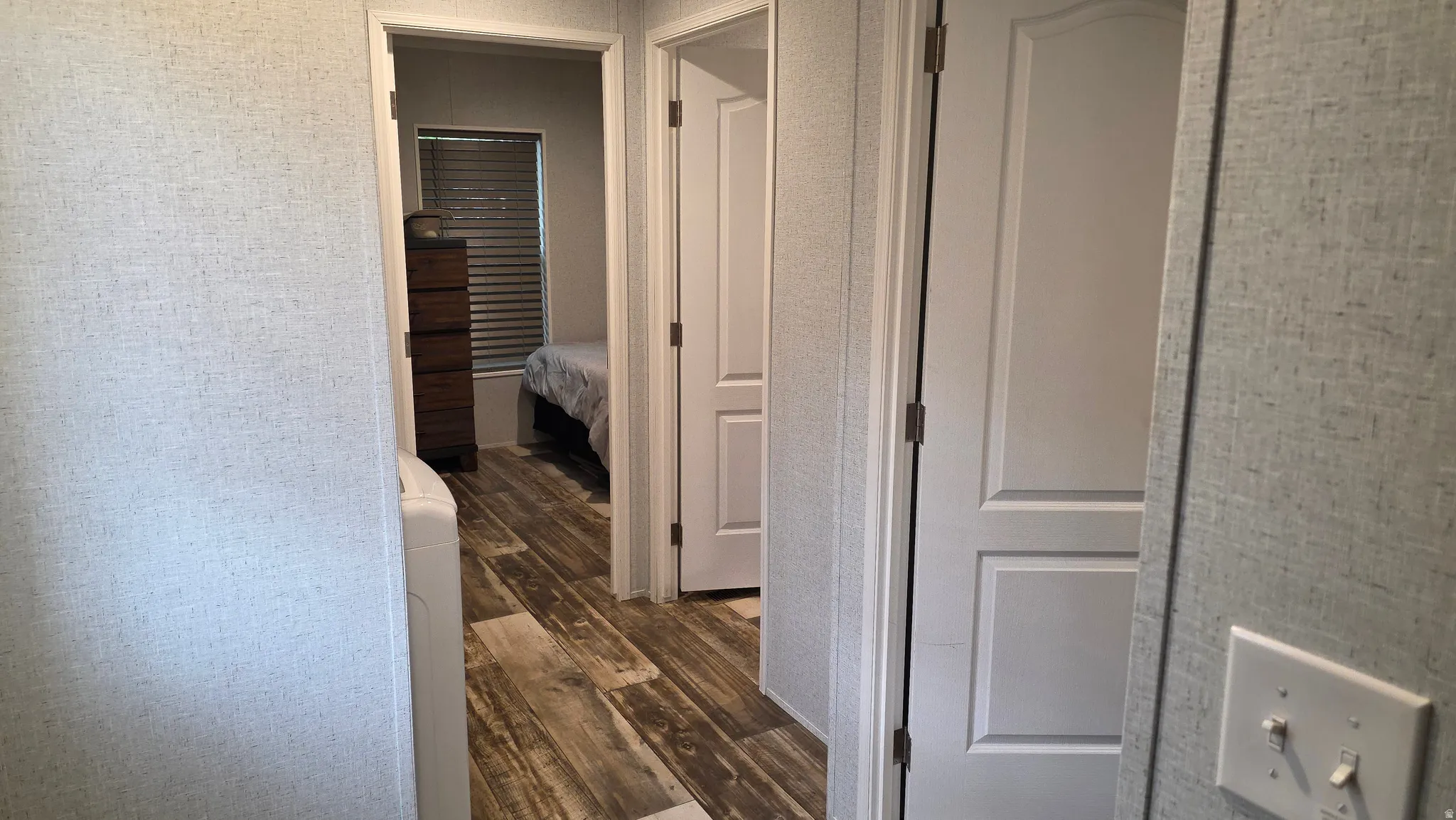 Wood-finish flooring throughout, white interior doors, and textured wall coverings