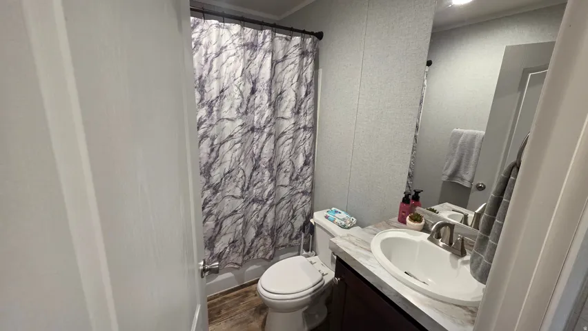 Vanity with a single basin sink, brushed nickel faucet, and wood-finish cabinetry