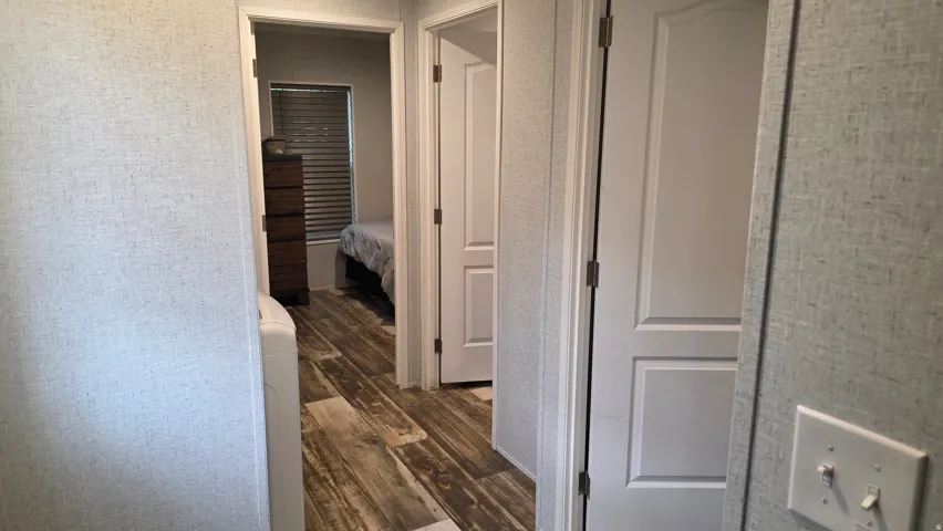 Wood-finish flooring throughout, white interior doors, and textured wall coverings