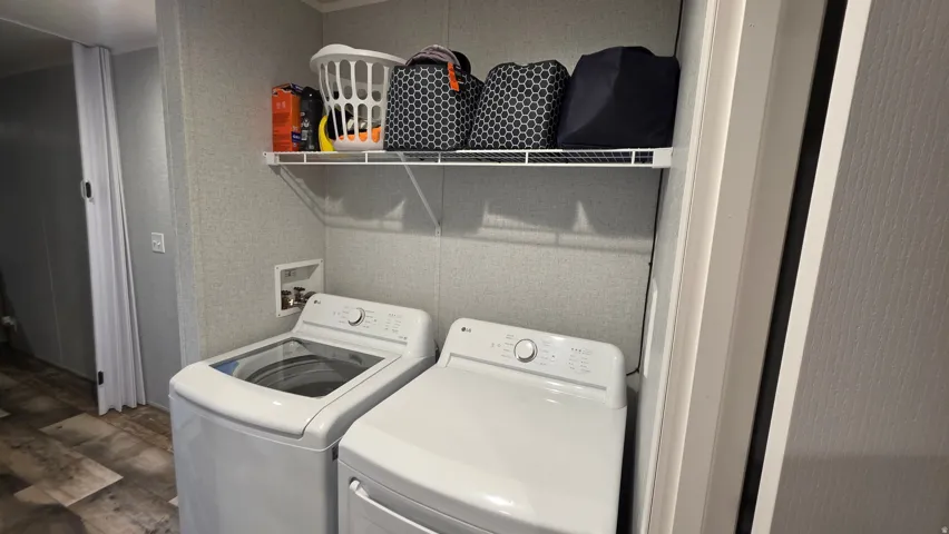 Utility area featuring wood-finish flooring and a wall-mounted wire shelf