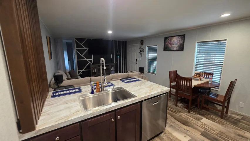 Kitchen island with a stainless steel sink, pull-down faucet, and light-toned countertop