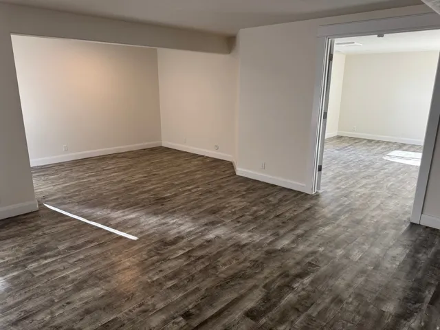 Expansive room featuring Vinyl flooring, light-toned walls, and white trim