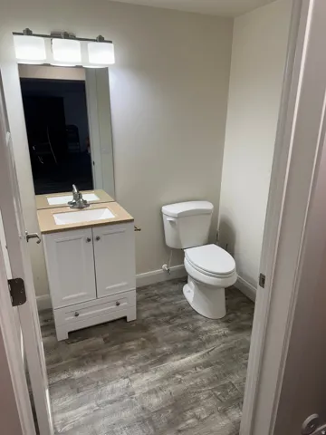 White vanity cabinet with chrome hardware, an integrated sink, and a light-toned countertop