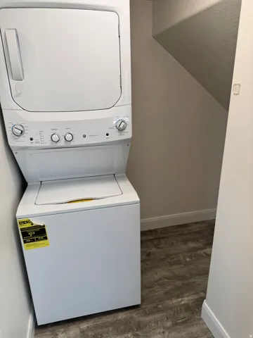 Stacked white laundry appliances with Vinyl flooring