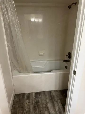 Shower-tub combination with bronze-finish fixtures and Vinyl flooring