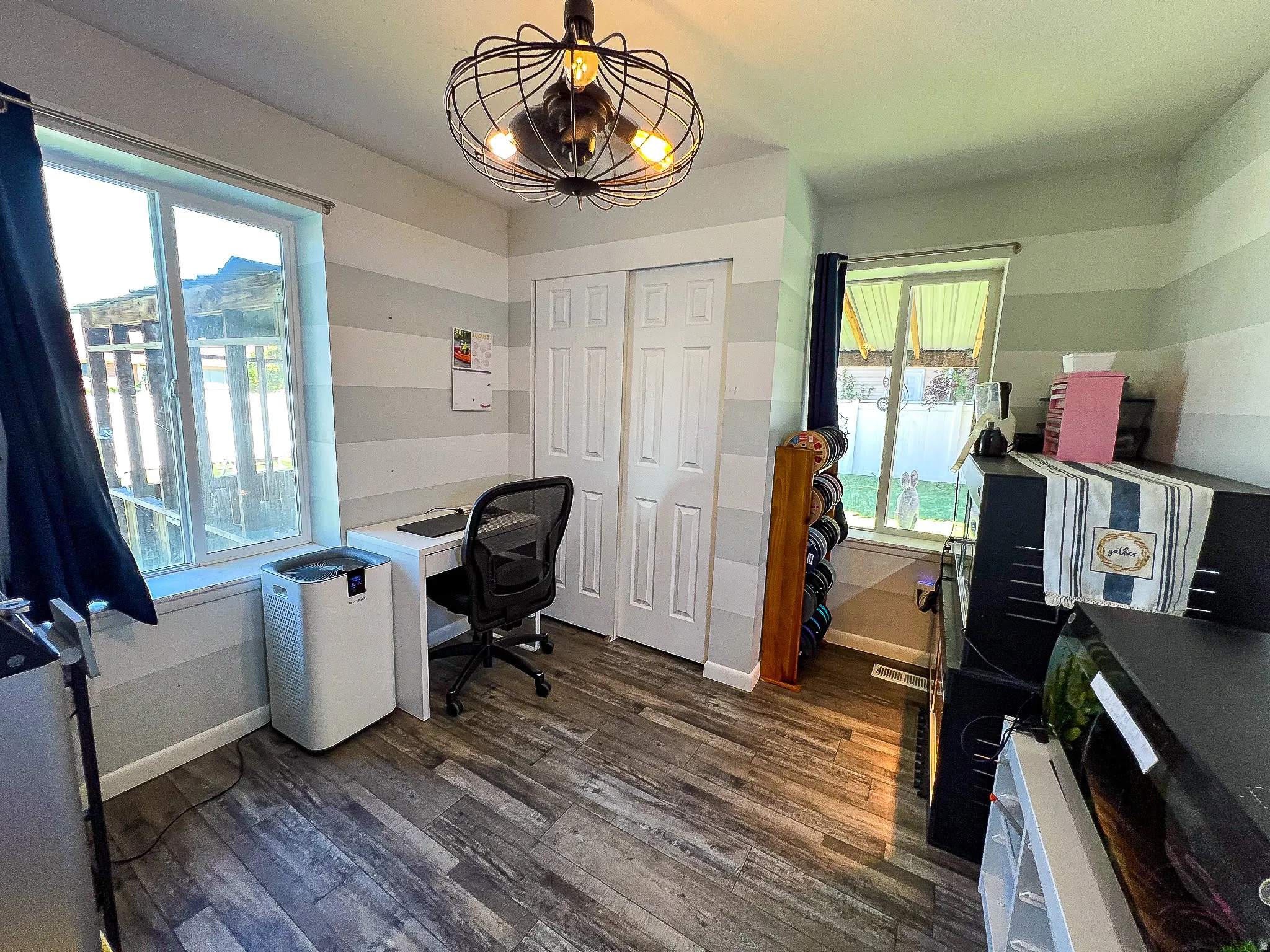 Wood-finish flooring, dual windows providing ample natural light, and a built-in closet with bi-fold doors