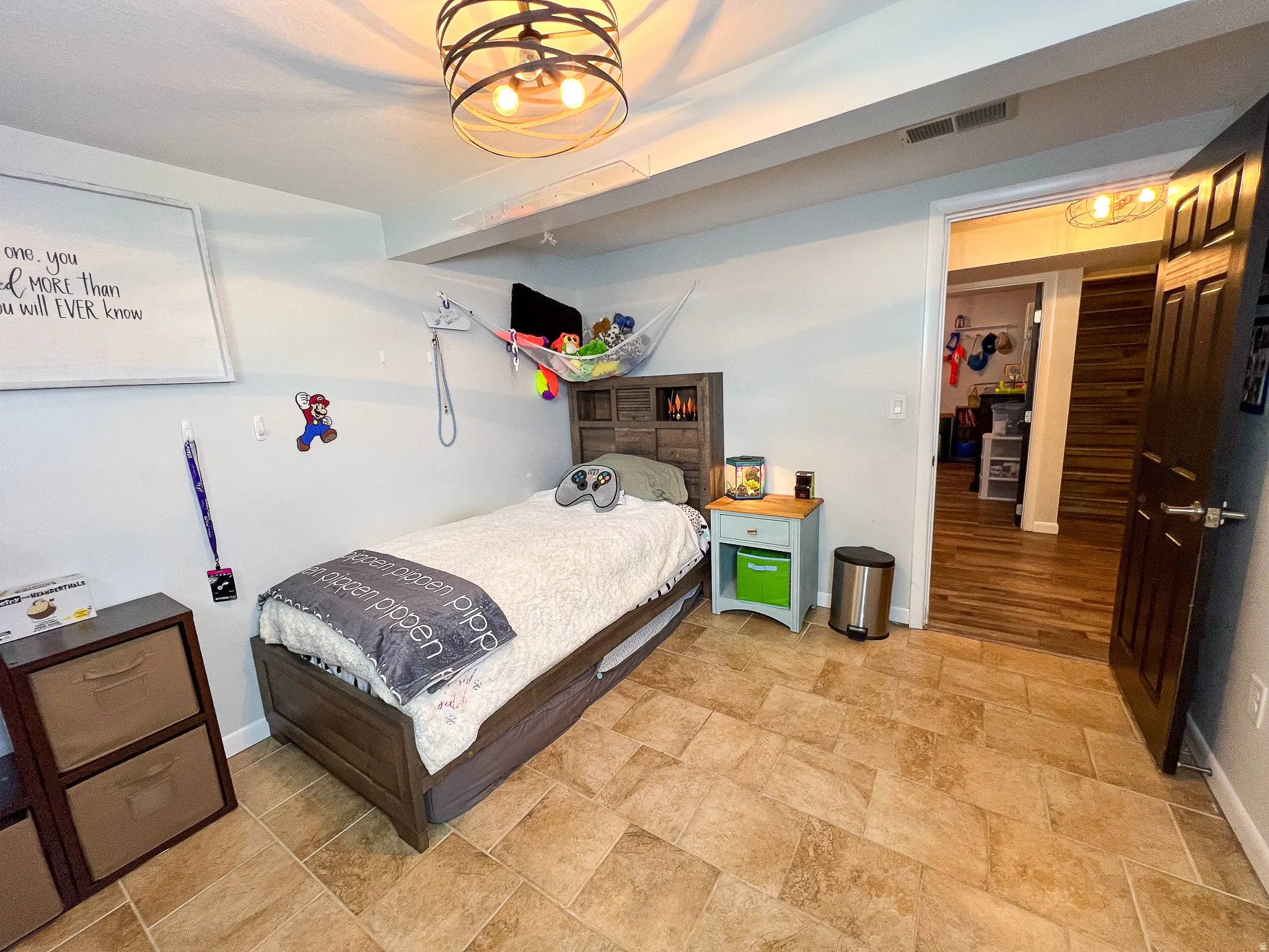 Recessed lighting, wood-look flooring, and a contemporary ceiling fixture enhance this versatile space