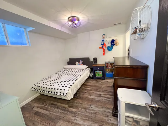 Room featuring wood-finish flooring, a window, and a ceiling-mounted light fixture