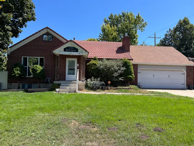 Brick exterior with a prominent front entrance, an attached garage, and a pitched roof