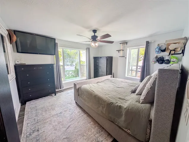 Recessed lighting, ceiling fan with light fixture, large windows, wood-finish flooring, and light-toned walls