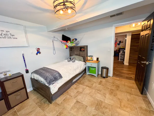 Recessed lighting, wood-look flooring, and a contemporary ceiling fixture enhance this versatile space