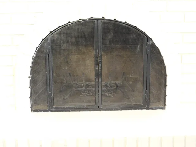 Fireplace. Arched fire screen with interior grate, set against a white brick surround
