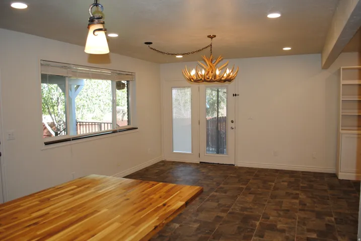 Butcher block countertop, recessed lighting,  and a decorative antler chandelier