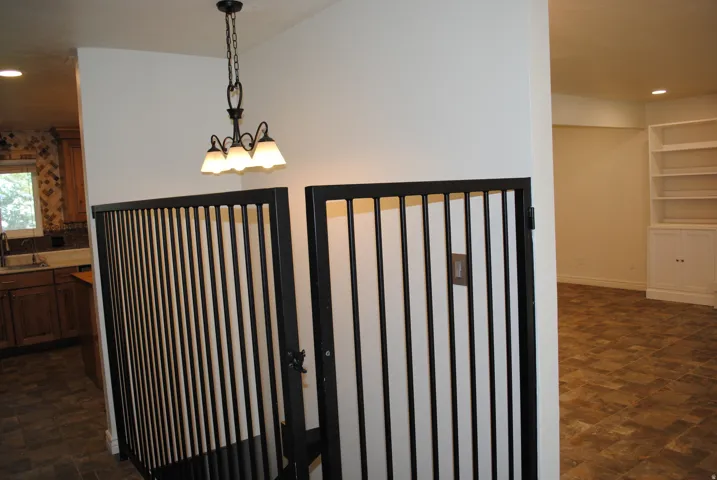 Black wrought iron-style railings with a matching chandelier