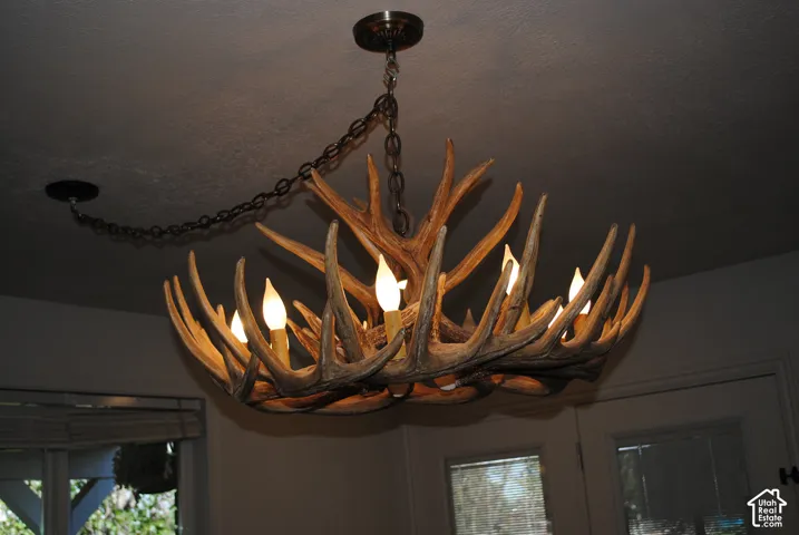 Antler-style chandelier with multiple candle-style lights, suspended by a metal chain