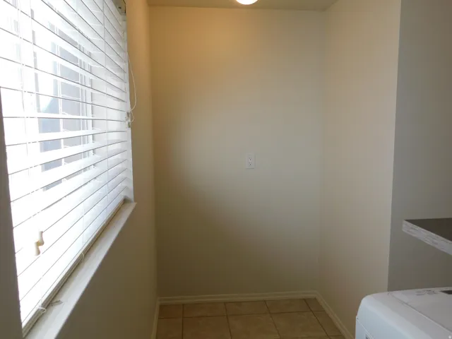 Window with horizontal blinds, neutral wall tones, tile flooring, and a recessed ceiling light