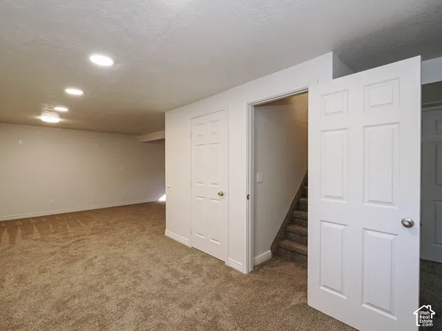 Finished interior space featuring neutral wall-to-wall carpeting, recessed ceiling lighting, and six-panel interior doors