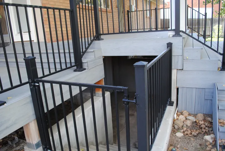 Deck with composite decking, black metal railings, and integrated stairs
