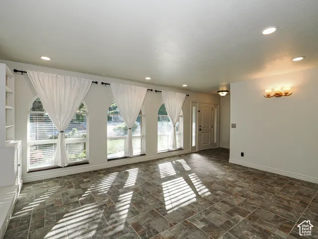 Arched windows, multi-tonal tile flooring, built-in shelving, recessed lighting, and wall-mounted light fixtures