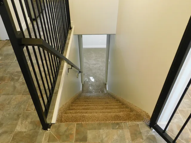 Tiled flooring, carpeted stairs, and a black wrought iron railing system