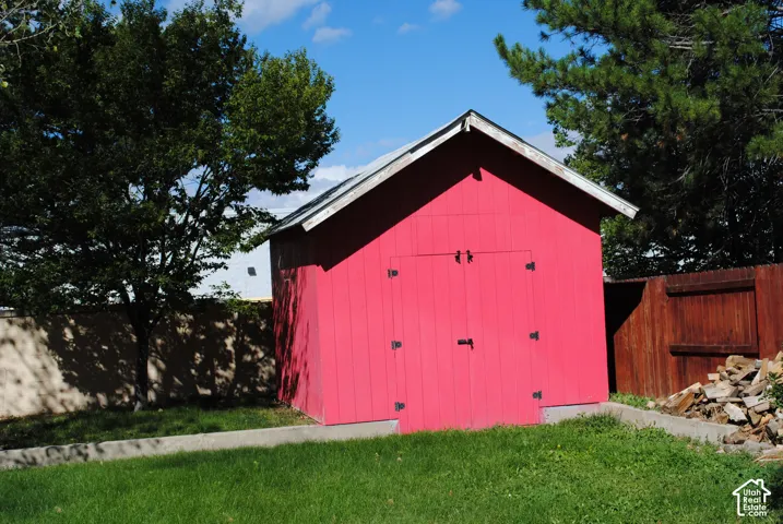 Red shed with double doors and a pitched roof, situated on concrete footings.
