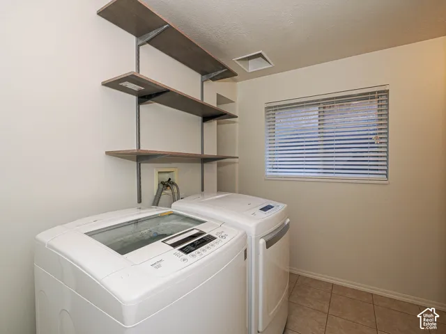Wall-mounted open shelving with metal support brackets, ceramic tile flooring, and horizontal window blinds