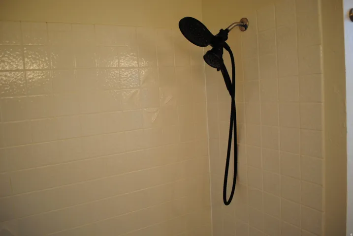 White tiled shower surround with a matte black dual shower head system