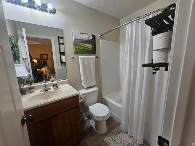 Single vanity with wood-finish cabinetry, integrated sink, and wall-mounted mirror