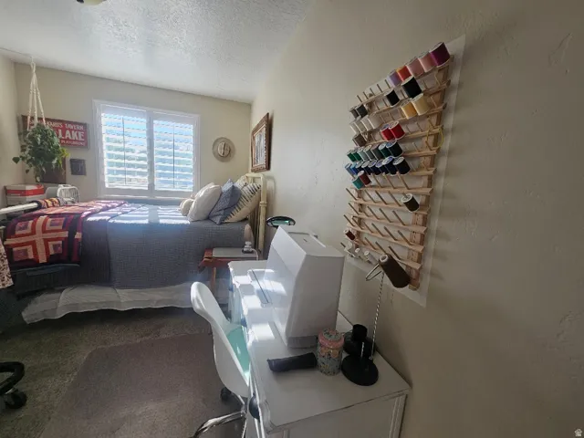 Window with louvered shutters, wall-mounted thread organizer, and neutral wall tones