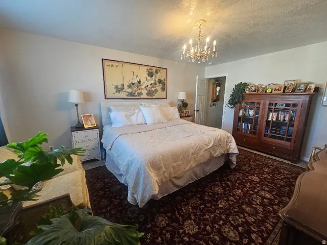 Ceiling-mounted crystal chandelier, textured ceiling, painted walls, and wood-finish door