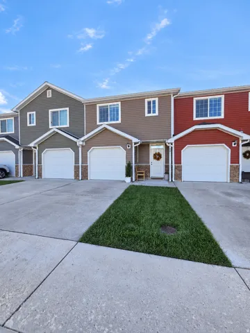 Multi-colored siding exterior with white trim, attached garages, and a concrete driveway