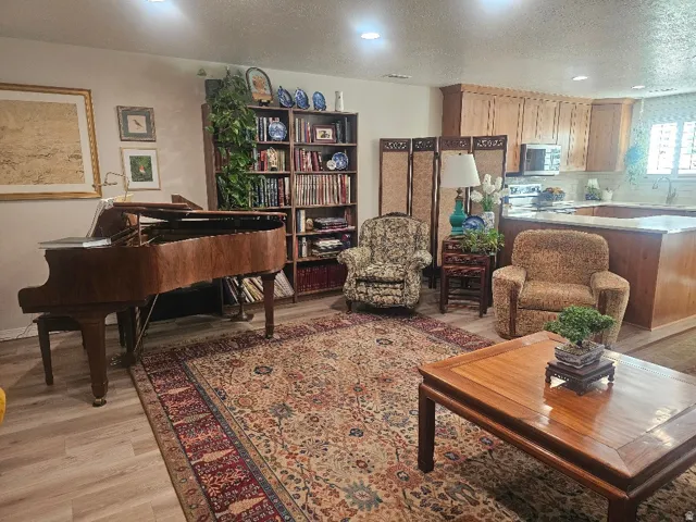 Recessed lighting, wood-finish flooring, built-in shelving, wood cabinetry, and a kitchen island with a countertop