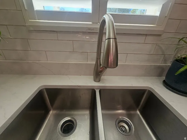 Stainless steel dual-basin undermount sink with polished chrome pull-down faucet
