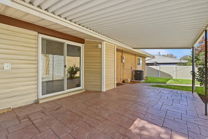 Covered patio featuring stamped concrete flooring, siding exterior, and sliding glass door access