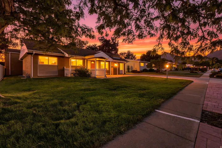Single-story residence featuring a covered front entry, established landscaping, and a sidewalk