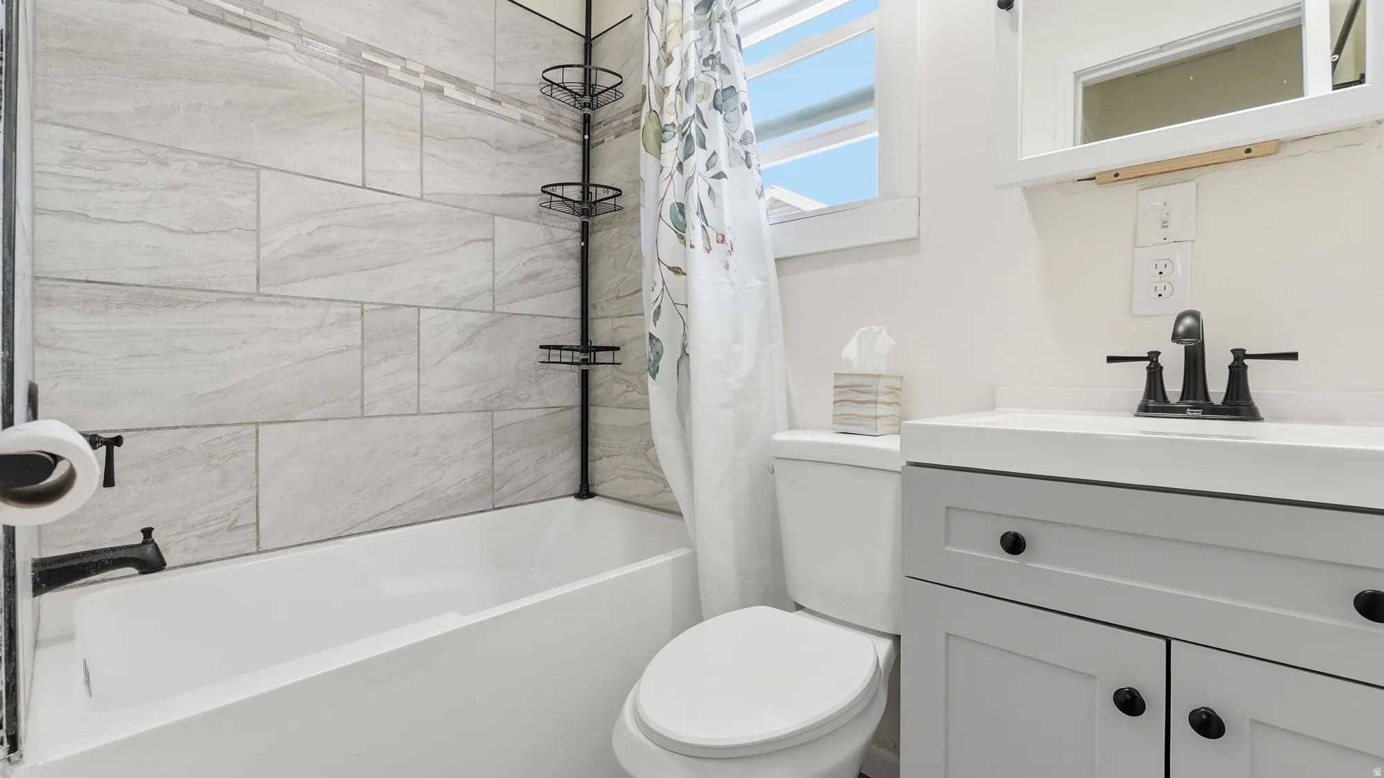 White vanity with black hardware, white countertop, and black faucet