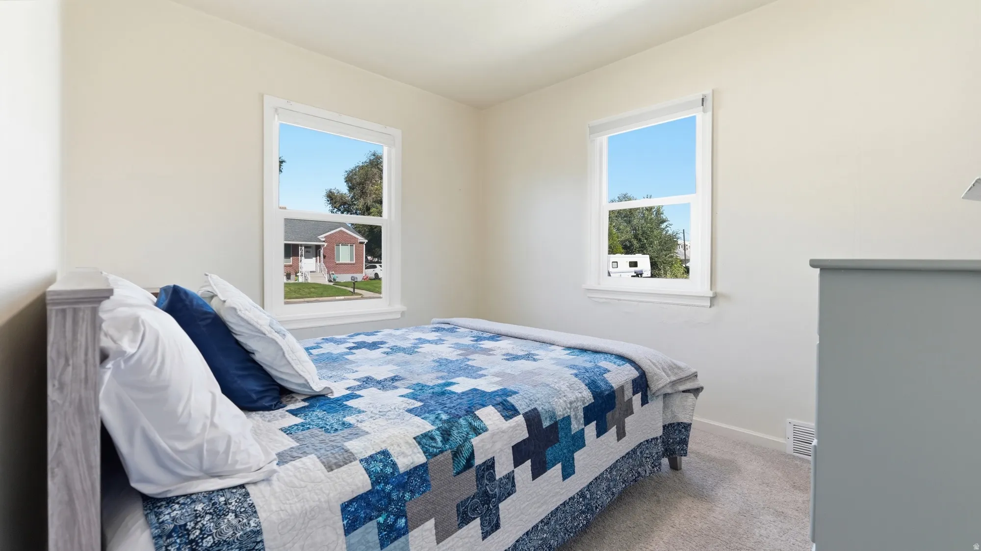 Neutral wall finishes, dual windows, and light-colored carpeting